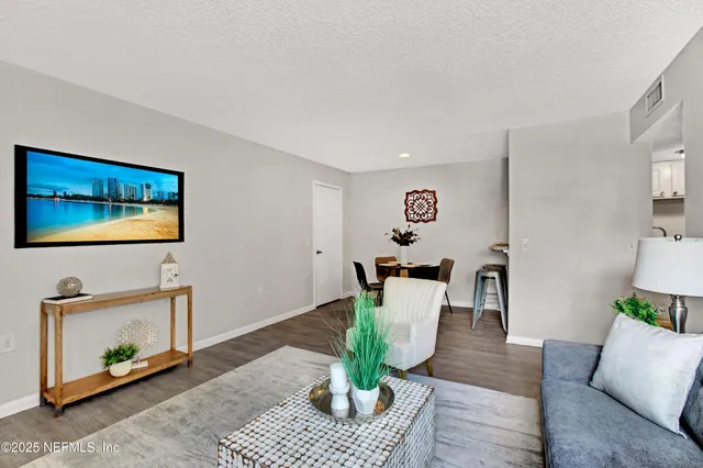 a living room with furniture potted plant and wooden floor