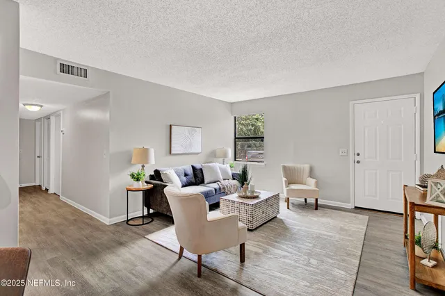 a living room with furniture and a wooden floor