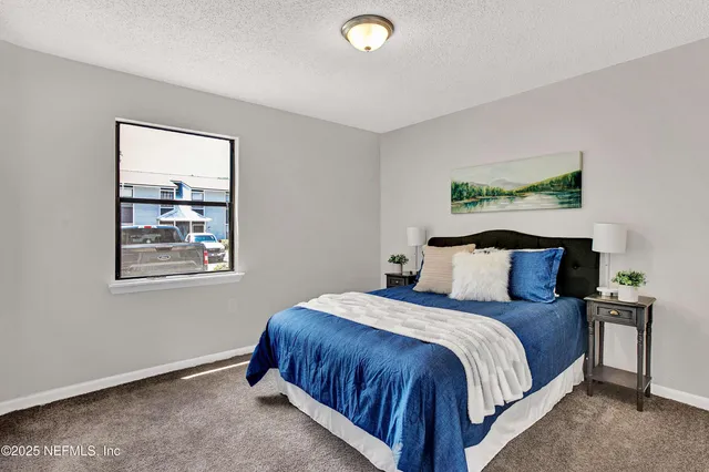 a large bed sitting in a bedroom next to a window