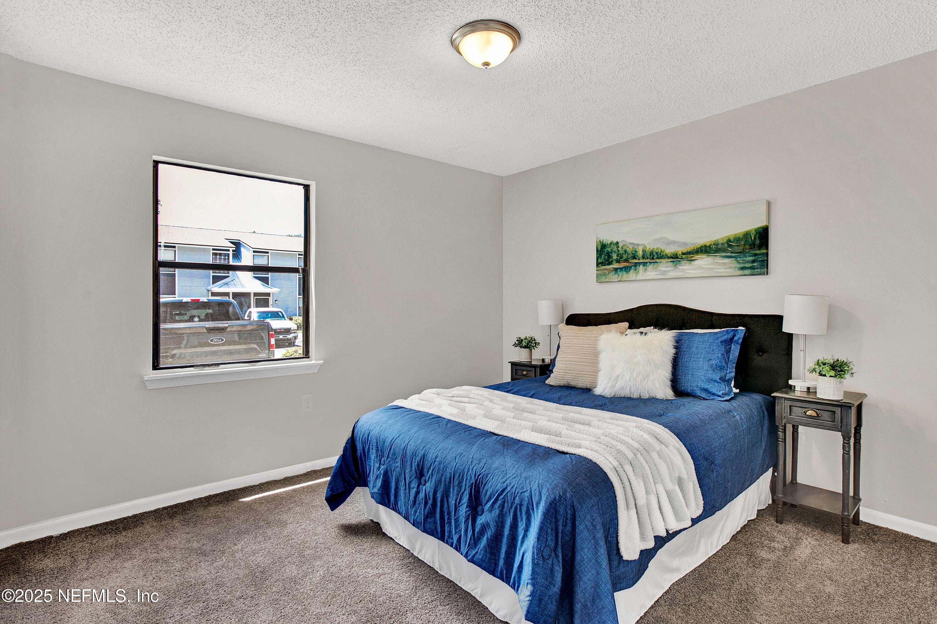 10825 Key Haven Boulevard, Unit 508 Jacksonville, FL 32218 - Photo 6 of 18 a large bed sitting in a bedroom next to a window