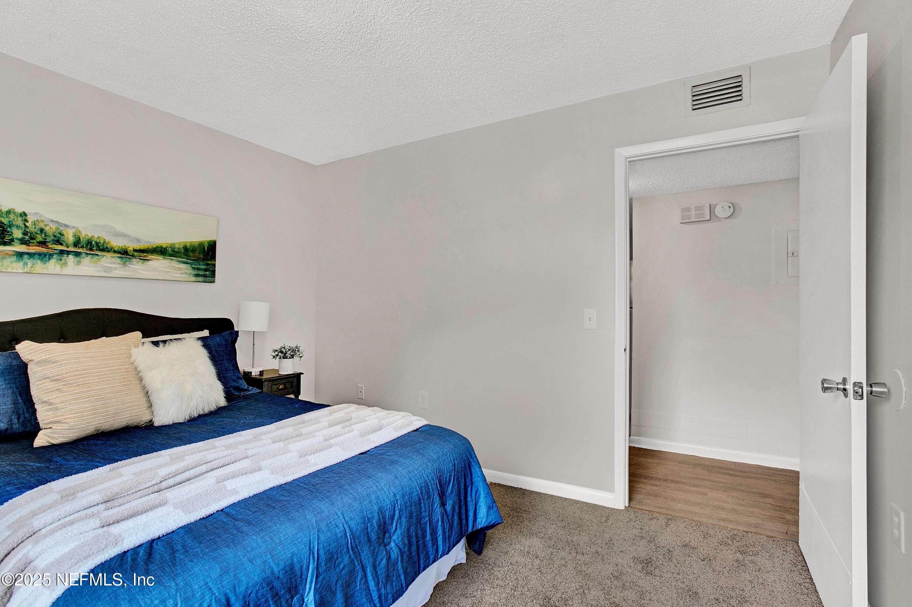 10825 Key Haven Boulevard, Unit 508 Jacksonville, FL 32218 - Photo 7 of 18 a bedroom with a bed and a painting on the wall