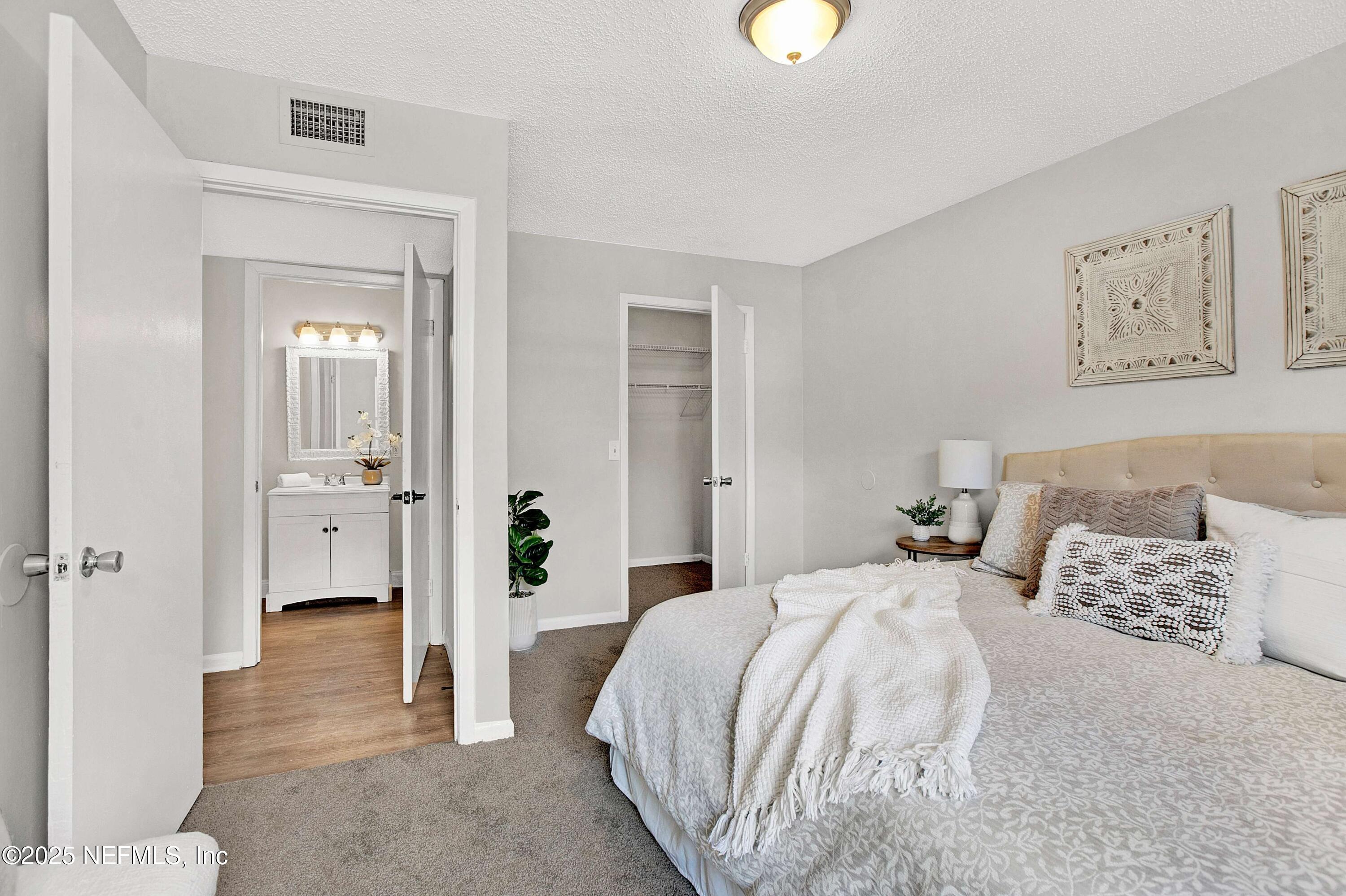 10825 Key Haven Boulevard, Unit 508 Jacksonville, FL 32218 - Photo 9 of 18 a bedroom with a bed and a view of bathroom