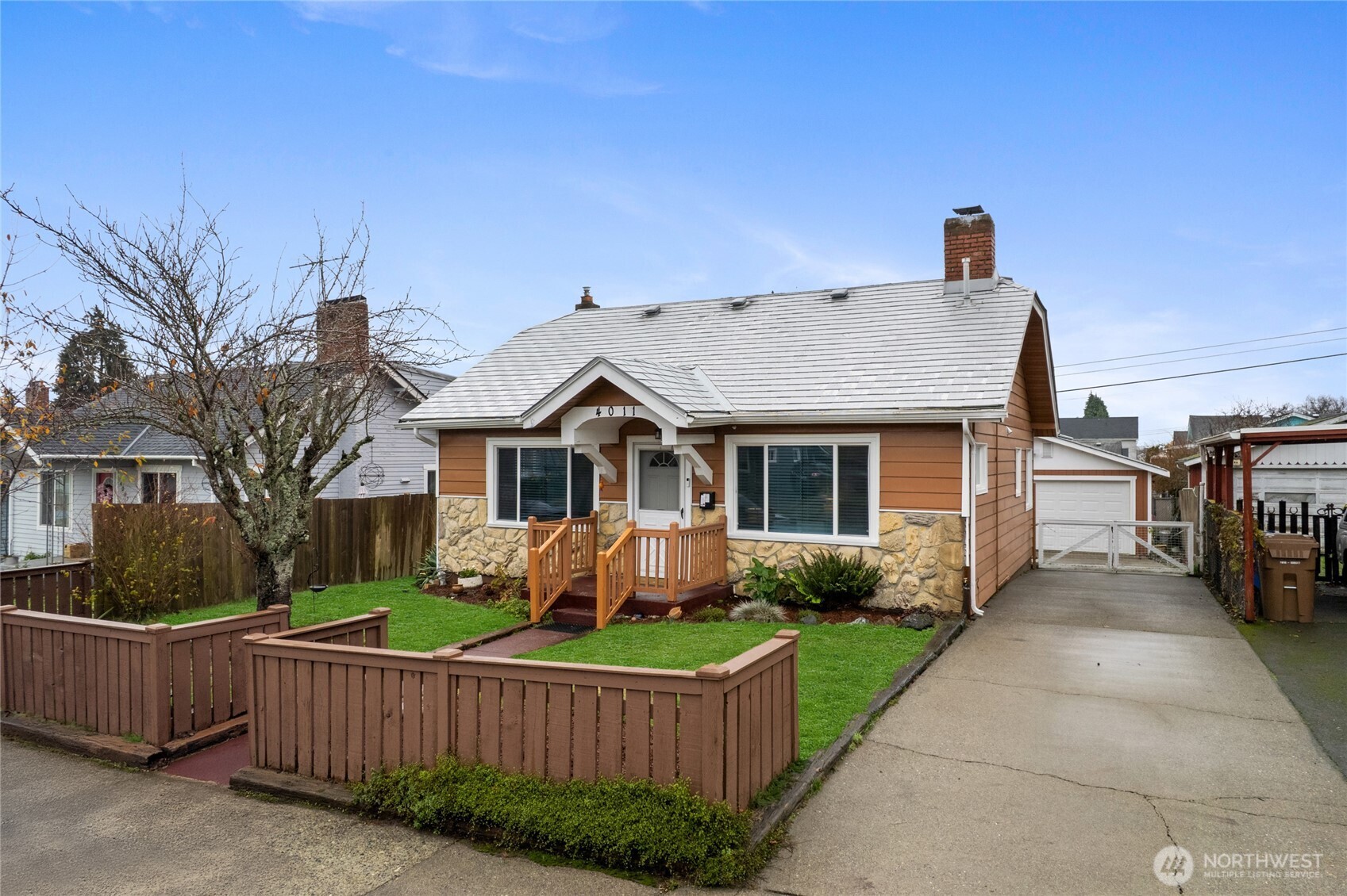 a front view of house with yard and trees in the background