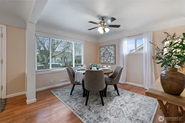 a dining room with furniture potted plants and wooden floor