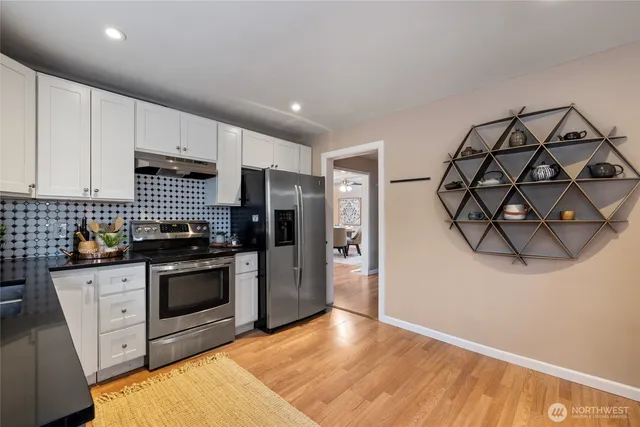 a kitchen with stainless steel appliances granite countertop a stove a sink and a refrigerator