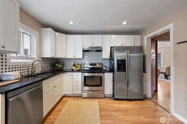a kitchen with a refrigerator sink and cabinets
