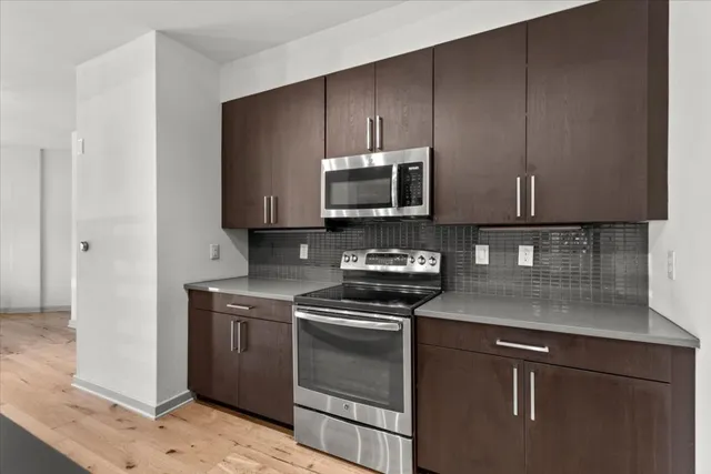 a kitchen with sink a microwave a stove and cabinets