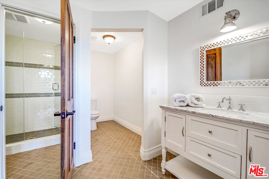 1405 Mayapan Road La Habra Heights, CA 90631 - Photo 46 of 54 a bathroom with a granite countertop sink a mirror and a vanity