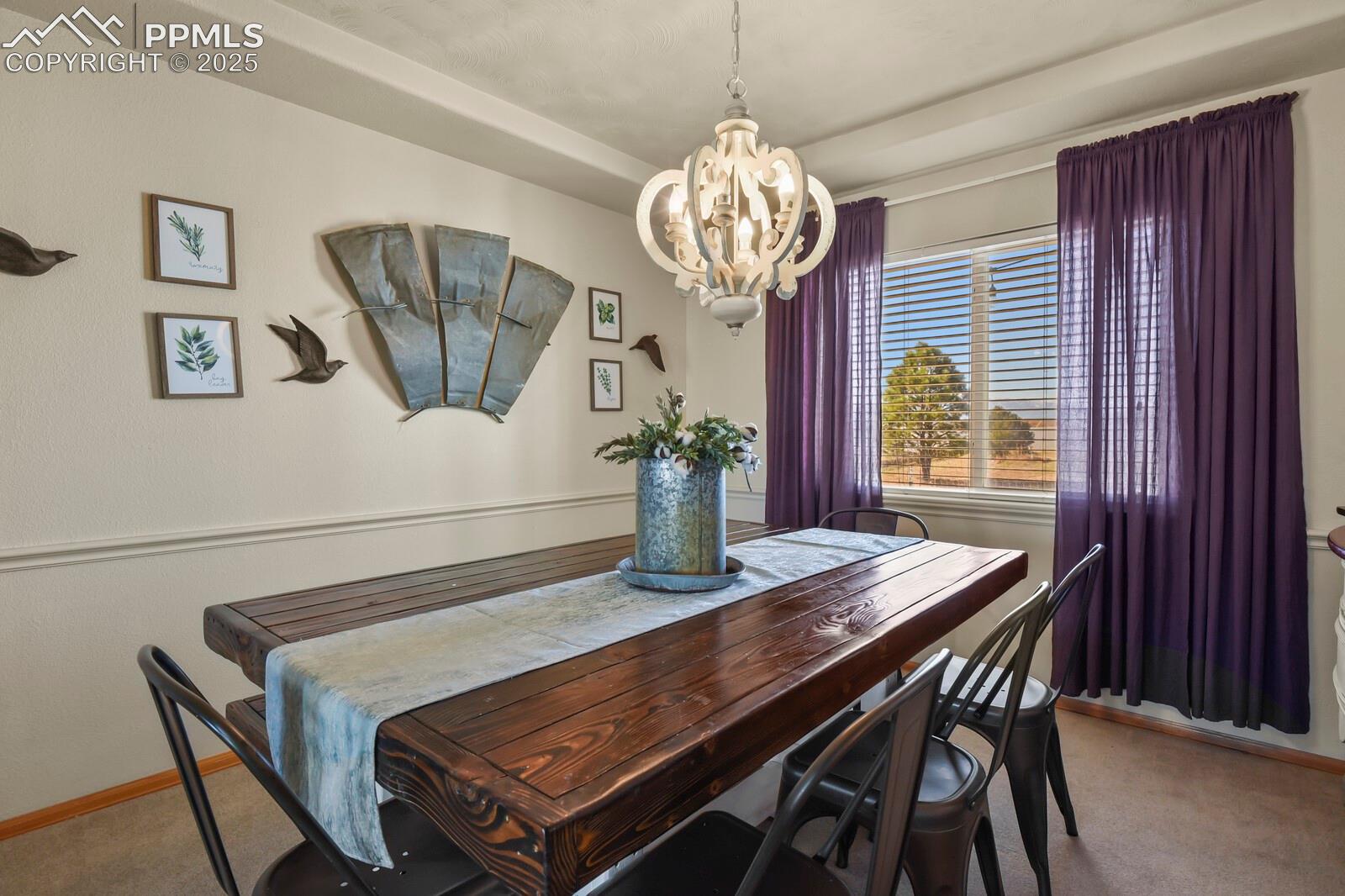 7660 Bullet Road Peyton, CO 80831 - Photo 9 of 50 Dining area with light carpet and a chandelier
