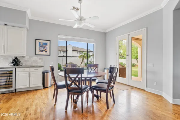 a dining room with wooden floor a chandelier a wooden table and chairs