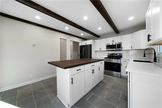 a kitchen with stainless steel appliances granite countertop a sink and a stove