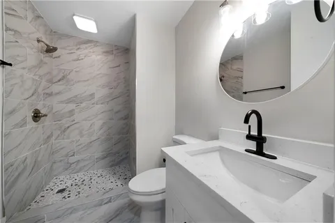 a bathroom with a sink a toilet and a mirror