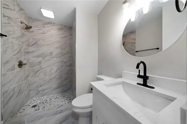 a bathroom with a sink a toilet and a mirror