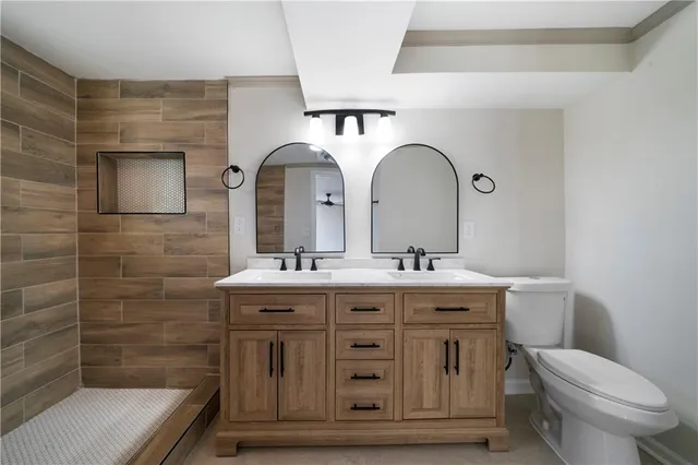 a bathroom with a granite countertop toilet a sink and mirror