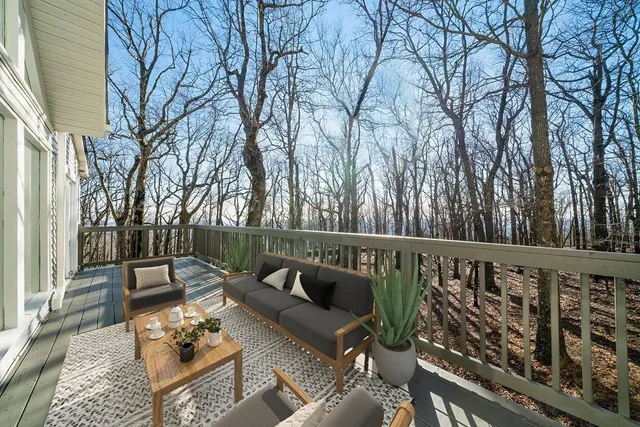 a view of deck with furniture and trees