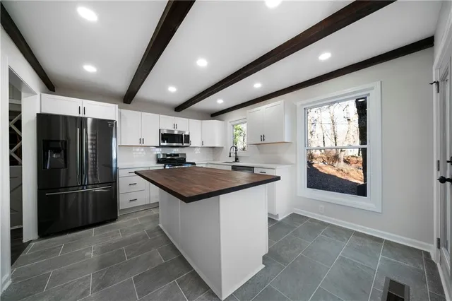 a kitchen with stainless steel appliances granite countertop a refrigerator and a sink