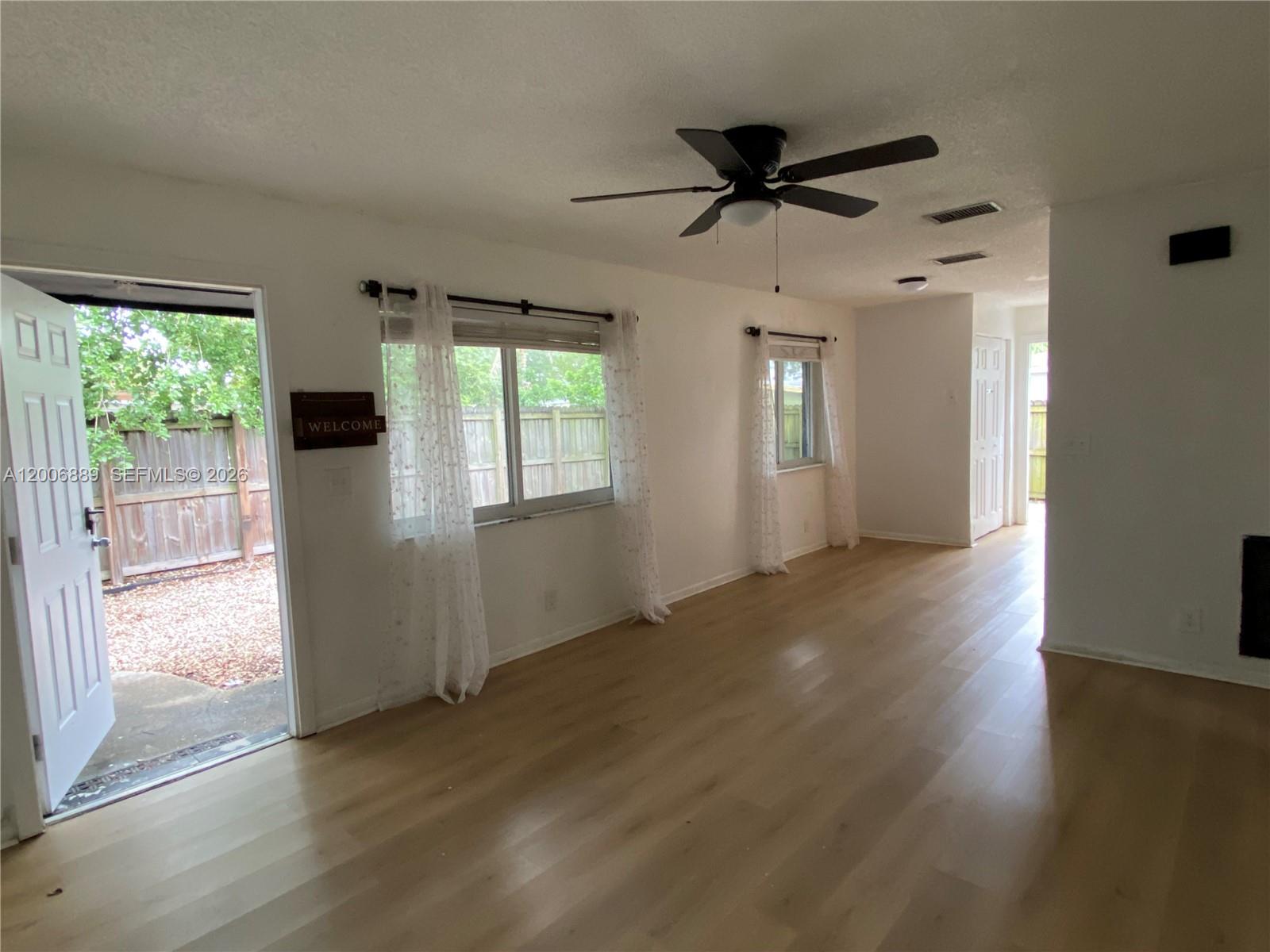 6132 Southwest 39th Street, Unit R Miramar, FL 33023 - Photo 6 of 21 an empty room with wooden floor fan and windows