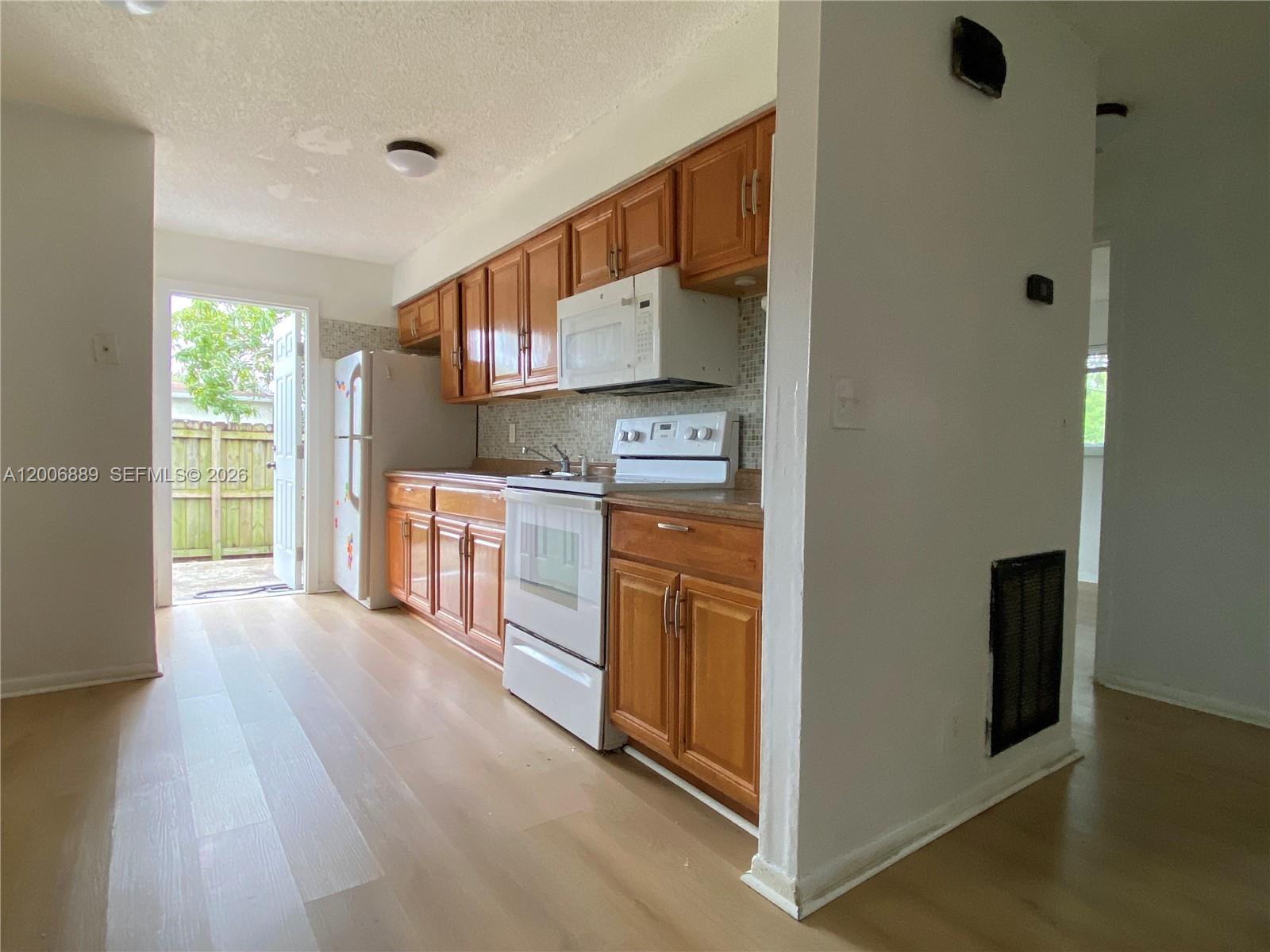 6132 Southwest 39th Street, Unit R Miramar, FL 33023 - Photo 7 of 21 a view of kitchen with stainless steel appliances granite countertop a stove and a refrigerator