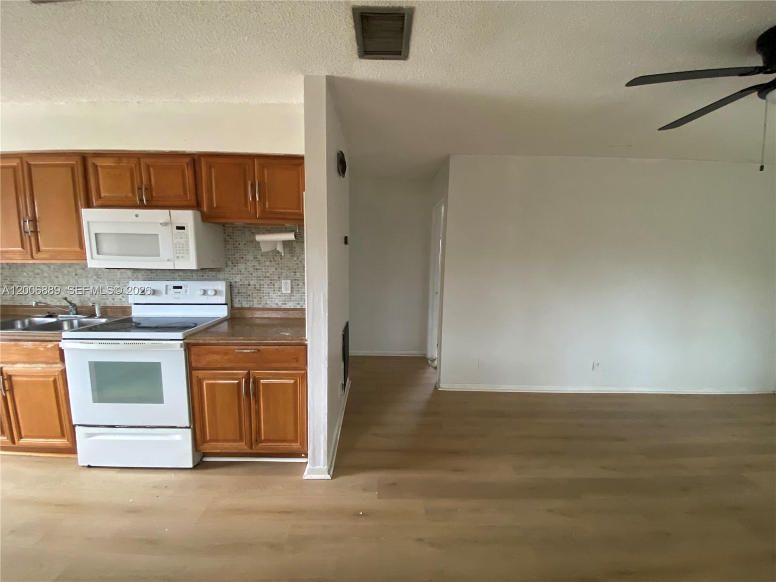 6132 Southwest 39th Street, Unit R Miramar, FL 33023 - Photo 9 of 21 a kitchen with granite countertop a stove and a refrigerator