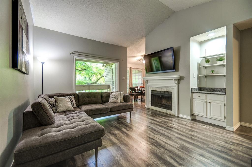 6315 Campbell Road, Unit 508 Dallas, TX 75248 - Photo 1 of 1 a living room with furniture a flat screen tv and a fireplace