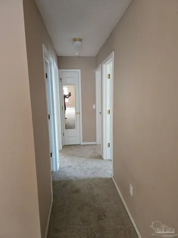 a view of a hallway with wooden shelves