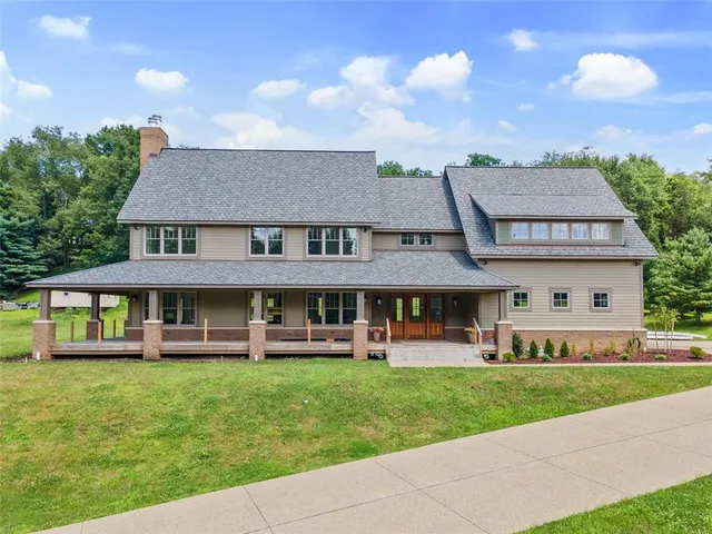 a front view of a residential houses with yard and green space