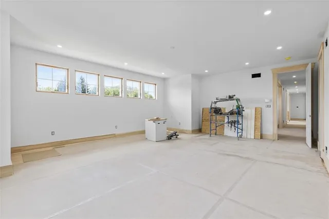 a spacious bathroom with a granite countertop sink a mirror a bathtub and next to a window