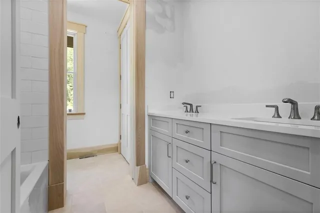 a bathroom with a granite countertop sink a toilet and bathtub