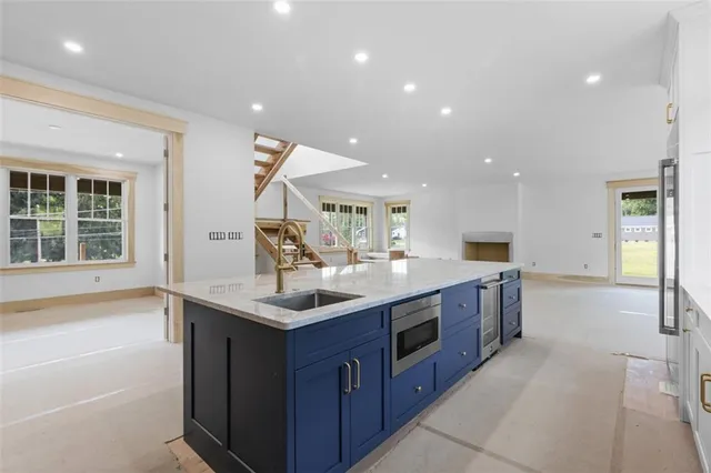 a kitchen with stainless steel appliances granite countertop a sink and a large window