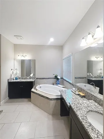 a spacious bathroom with a granite countertop tub sink and mirror
