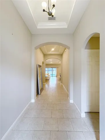 a living room with furniture kitchen view and a chandelier