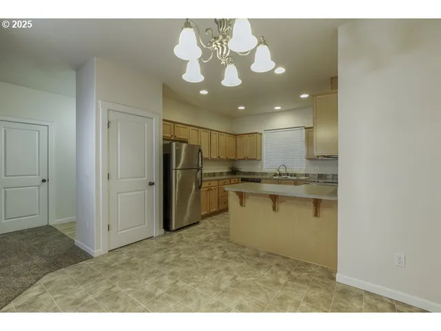 a open kitchen with a sink and refrigerator