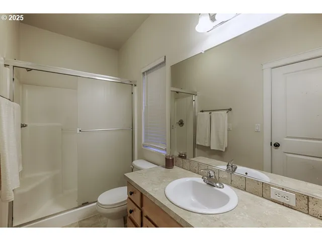 a bathroom with a sink toilet a mirror and shower