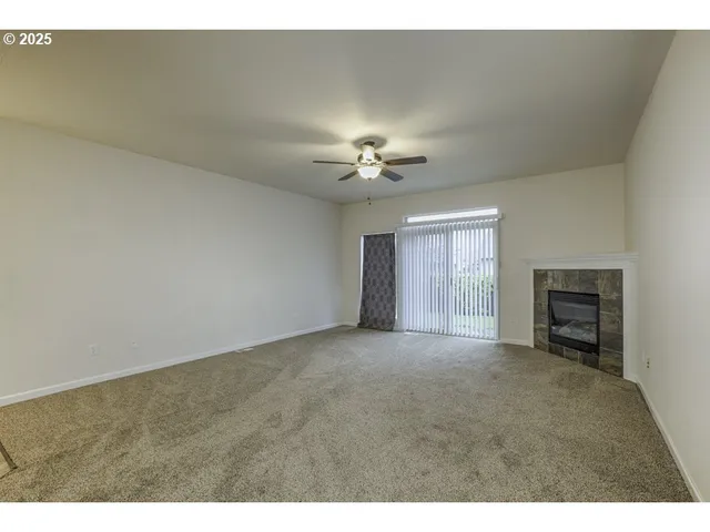 a view of a livingroom with a ceiling fan and window