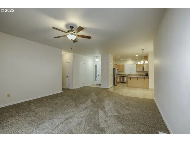 a view of an empty room and kitchen view