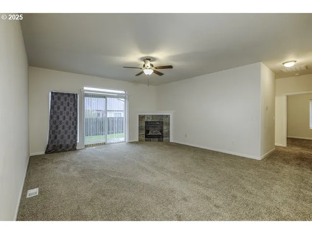 a view of a livingroom with a ceiling fan and window
