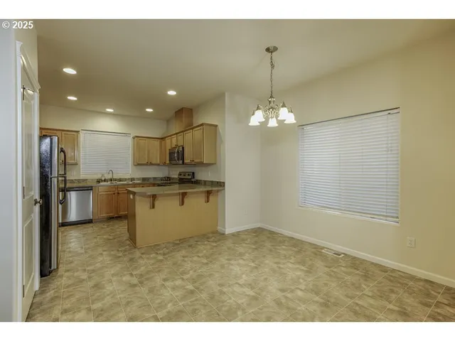 a view of a kitchen with a sink and refrigerator