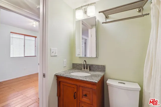 a bathroom with a granite countertop sink toilet and shower