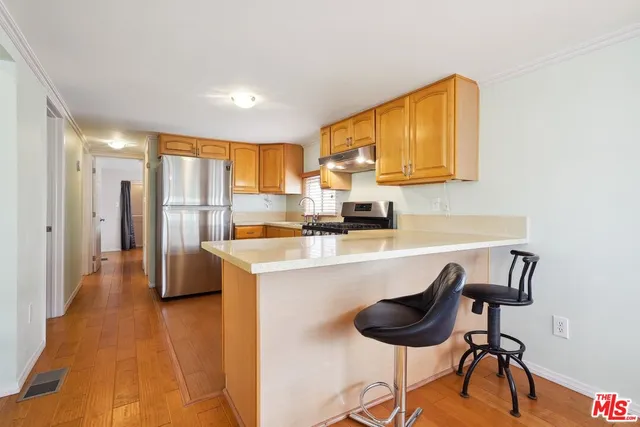 a kitchen with stainless steel appliances granite countertop a sink and a refrigerator
