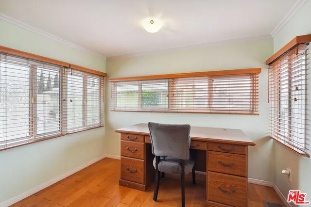 a view of a workspace with furniture and a window