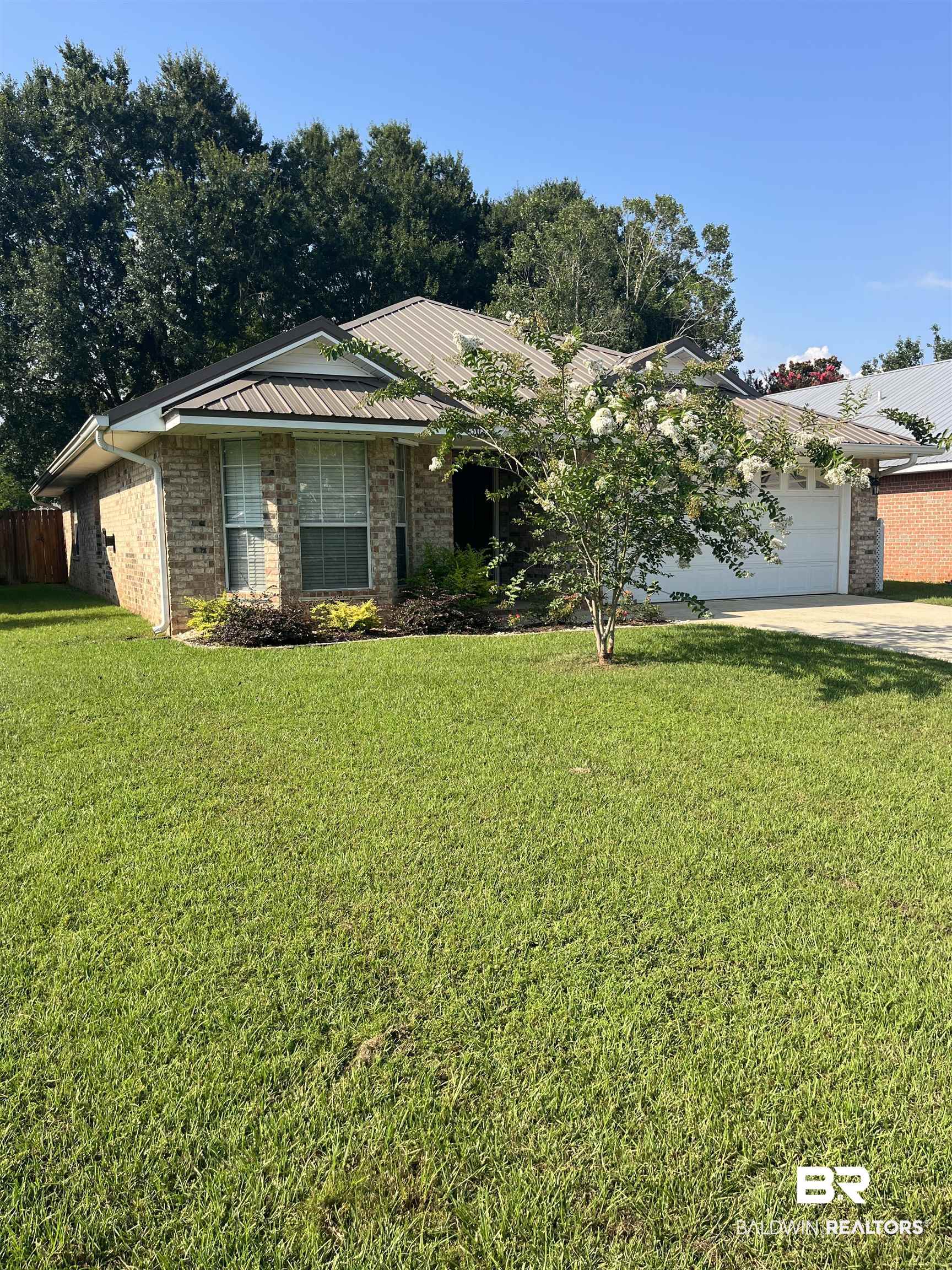 309 Cluster Street Foley, AL 36535 - Photo 2 of 38 Brick facade residence with a metal roof and an attached two-car garage