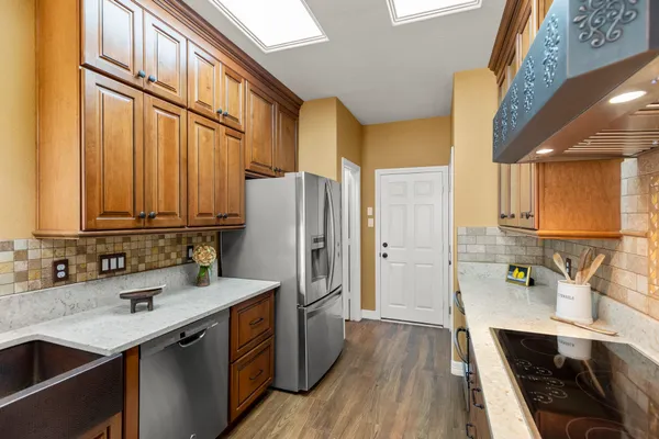 a kitchen with stainless steel appliances granite countertop a sink stove and cabinets
