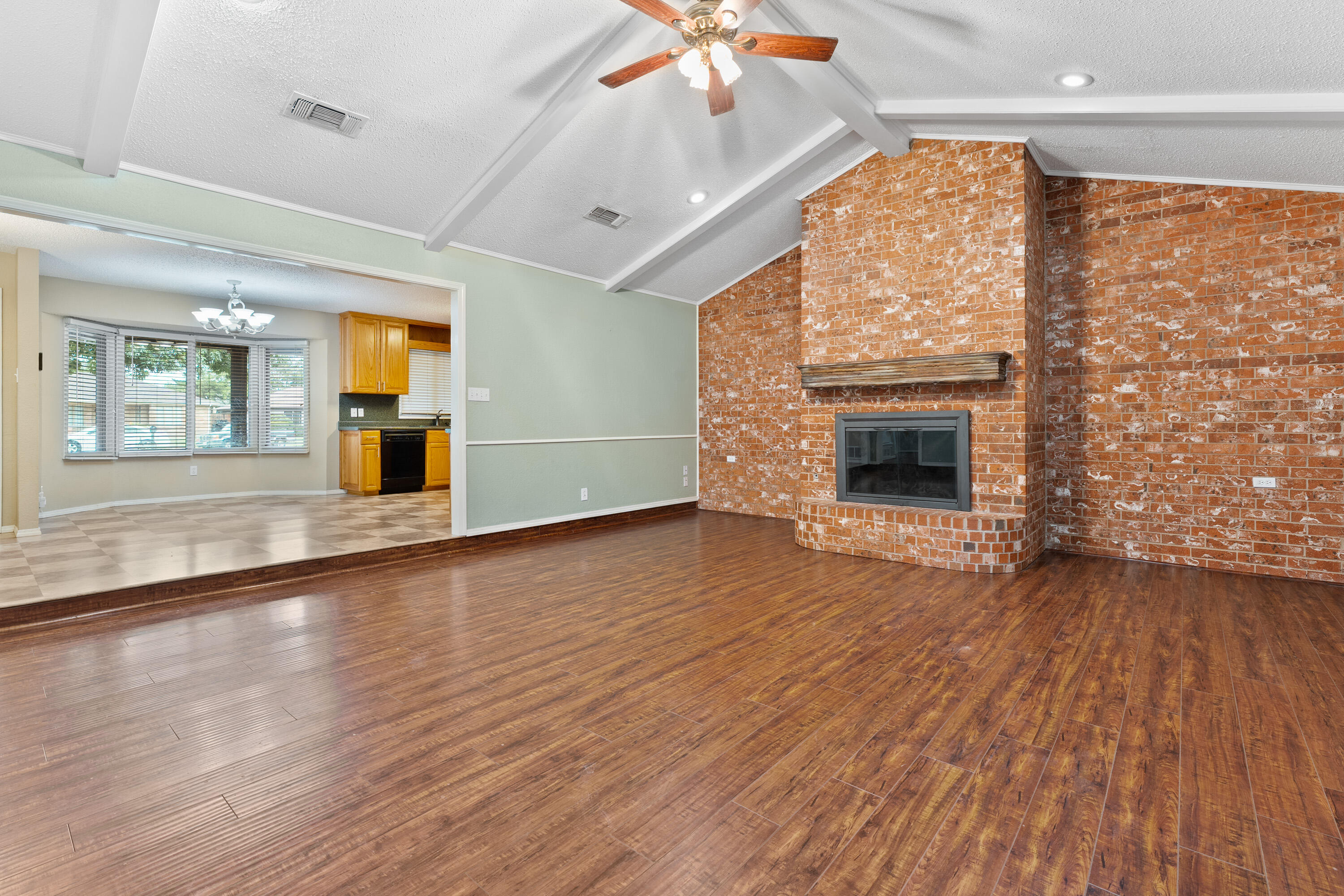 4403 78th Street Lubbock, TX 79424 - Photo 12 of 29 an empty room with wooden floor fireplace and windows