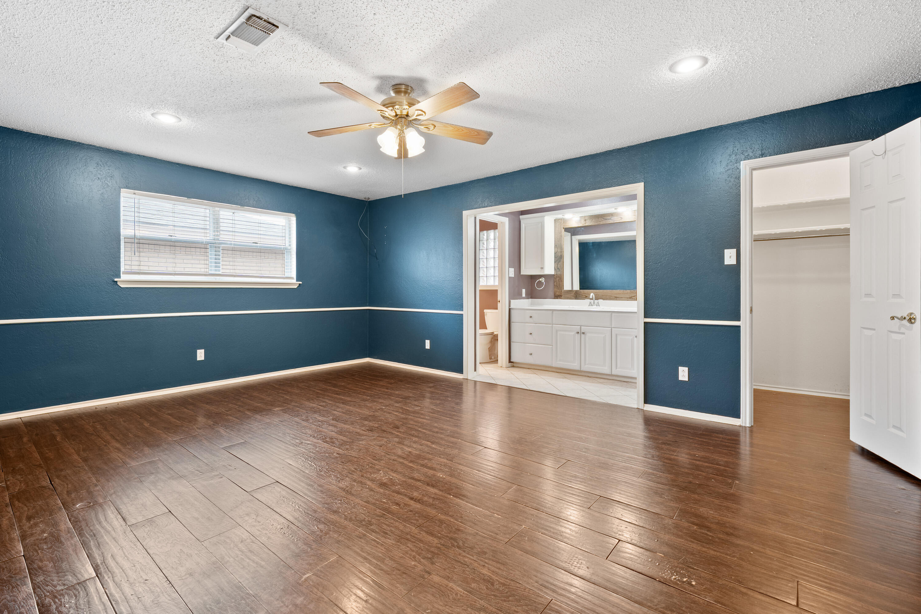 4403 78th Street Lubbock, TX 79424 - Photo 14 of 29 a view of an empty room with wooden floor and a window