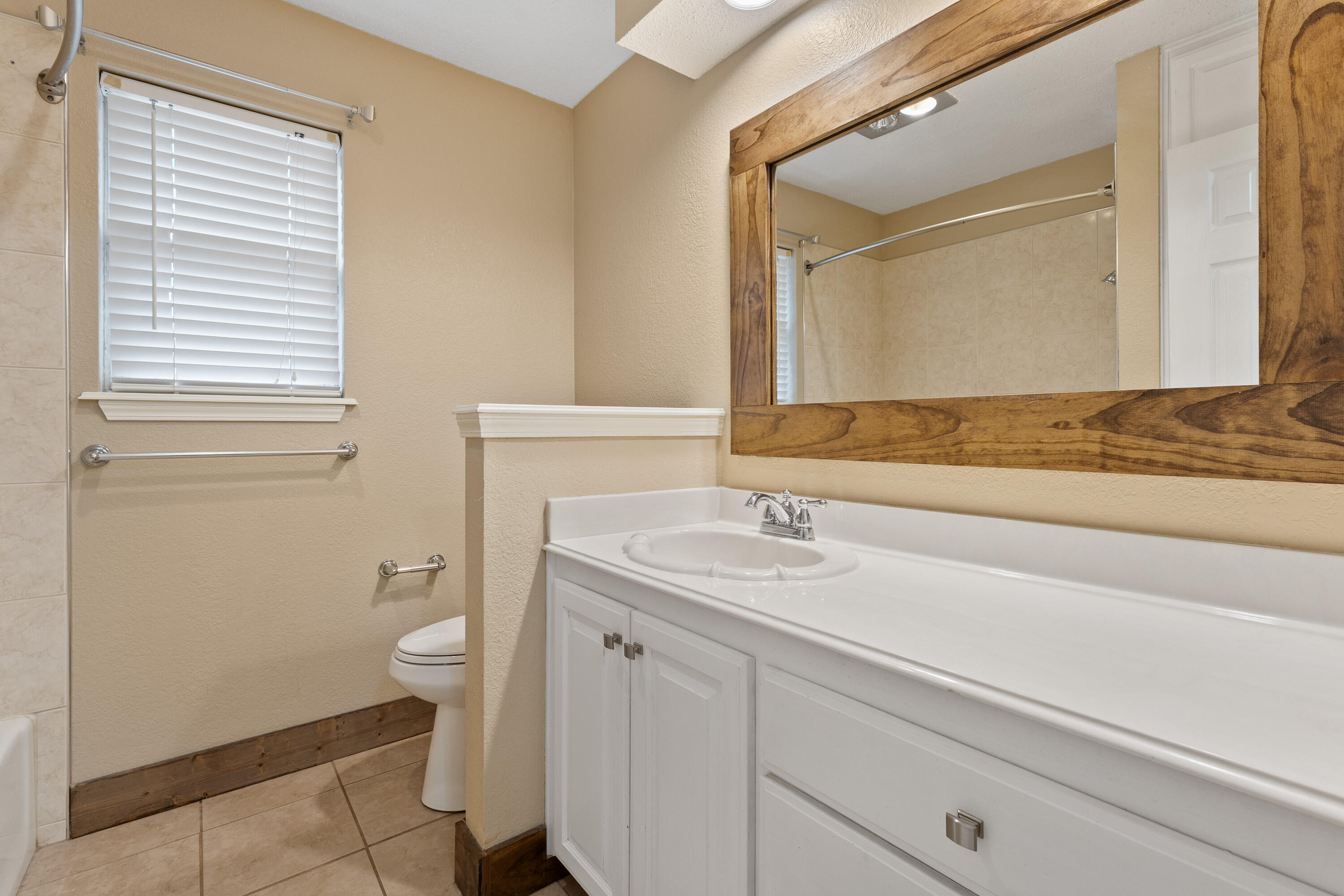 4403 78th Street Lubbock, TX 79424 - Photo 21 of 29 a bathroom with a granite countertop sink toilet and mirror