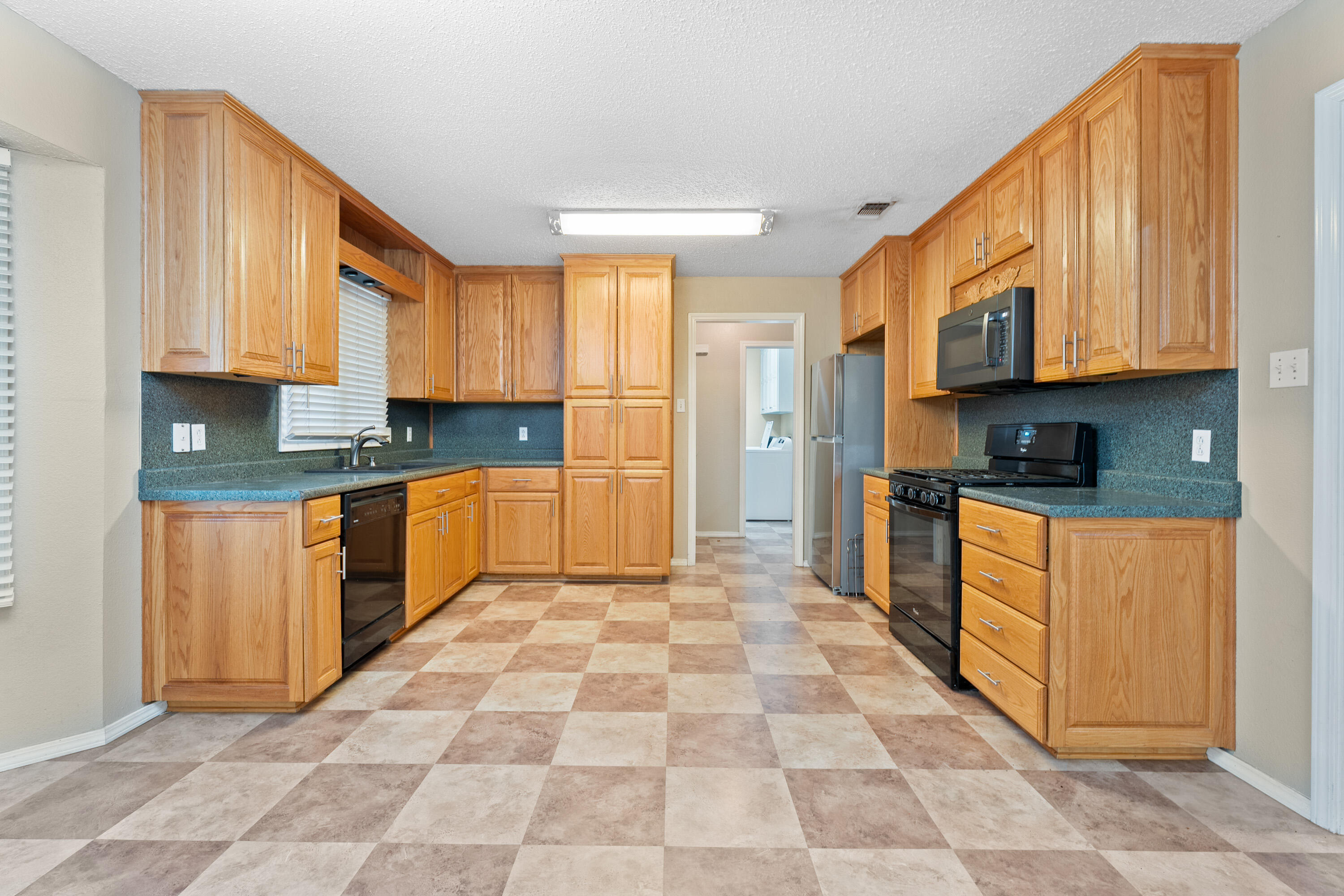 4403 78th Street Lubbock, TX 79424 - Photo 7 of 29 a kitchen with stainless steel appliances granite countertop a stove a sink and a refrigerator