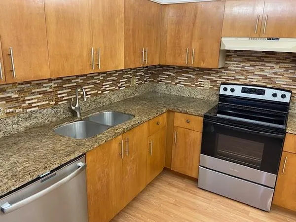 a kitchen with granite countertop a sink and cabinets