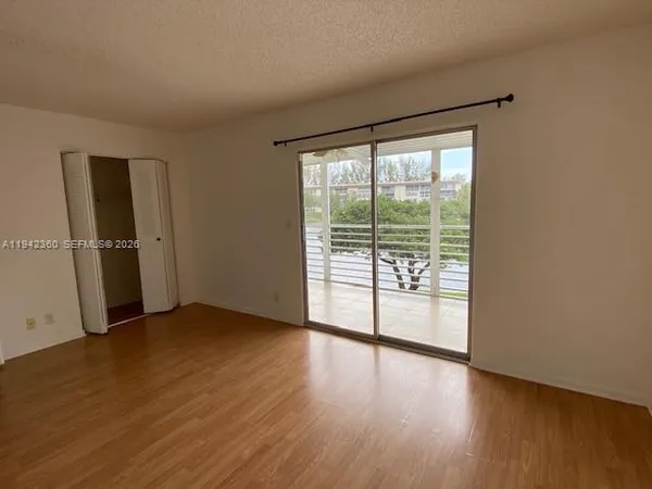 a view of a room with wooden floor and sliding window