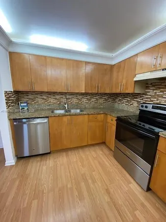 a kitchen with stainless steel appliances granite countertop a stove a sink and a microwave