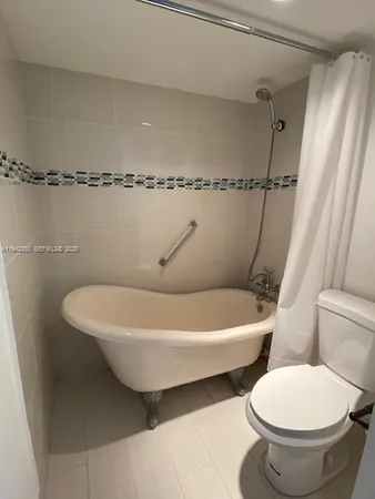 a white toilet sitting next to a bathtub